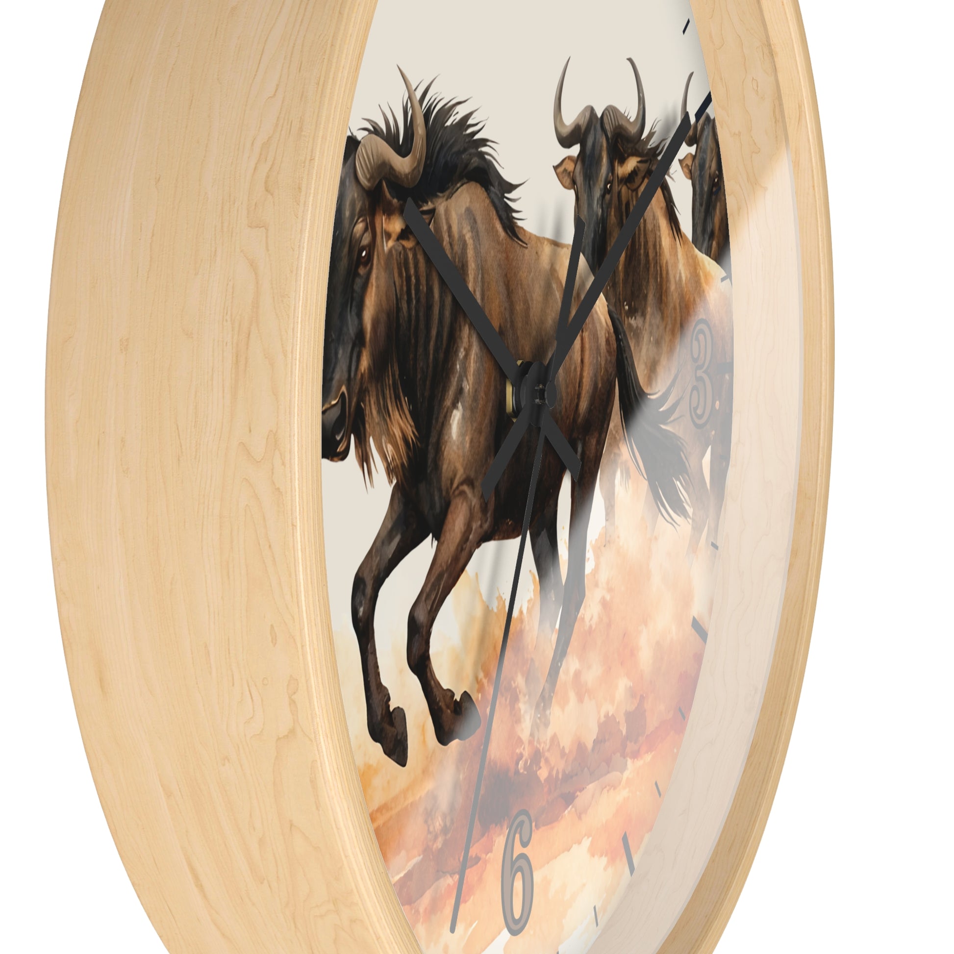 Round wall clock with a light natural wood frame and a printed face showing two brown wildebeest against a warm cream and orange sky. Black clock hands and small black numeral markers are visible.