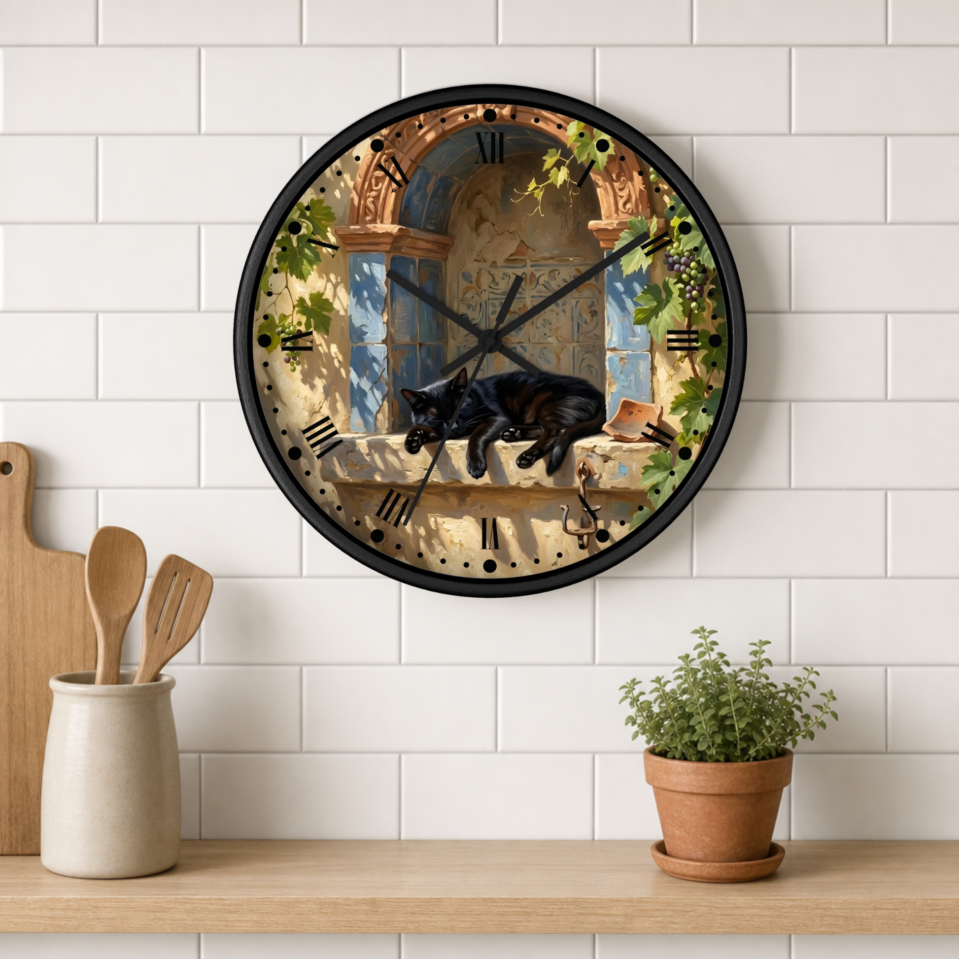 A round wall clock with a black cat sleeping on a stone windowsill against a classical architectural background, mounted on a white subway tile wall above a wooden shelf with kitchen utensils and a potted plant.