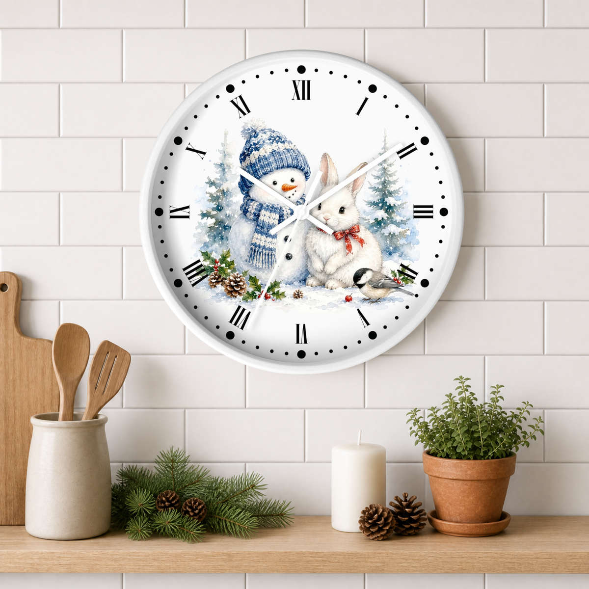 A round white wall clock with a winter holiday illustration of a snowman and rabbit, mounted on a white subway tile wall above a wooden shelf with kitchen decor.