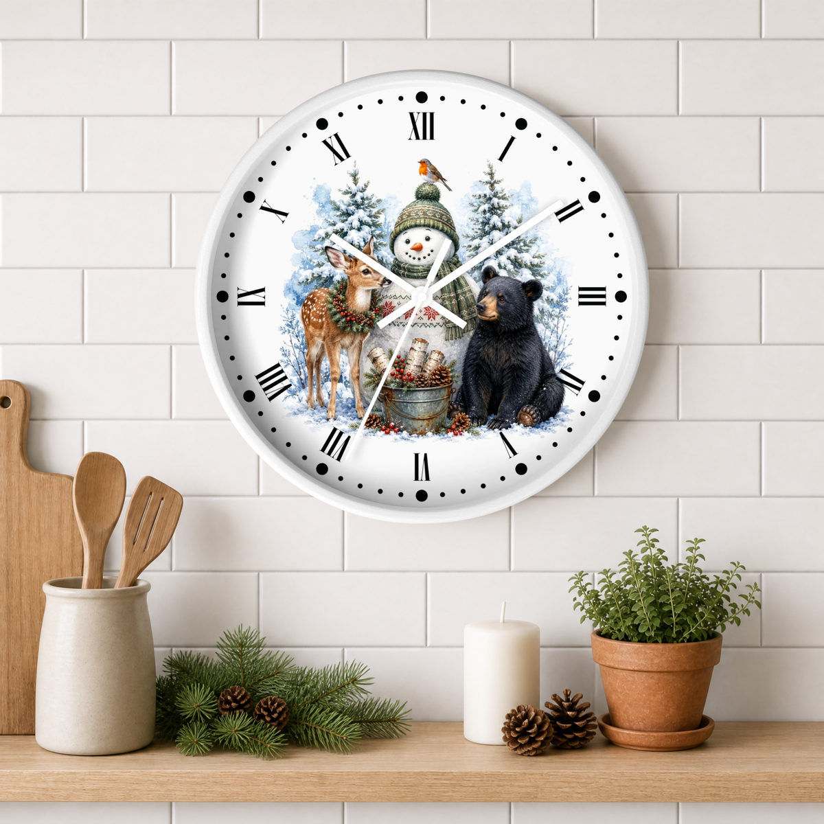 A round wall clock with a winter holiday illustration featuring a snowman, deer, snowbird, and bear, mounted on a white subway tile wall above a wooden shelf with kitchen decor.