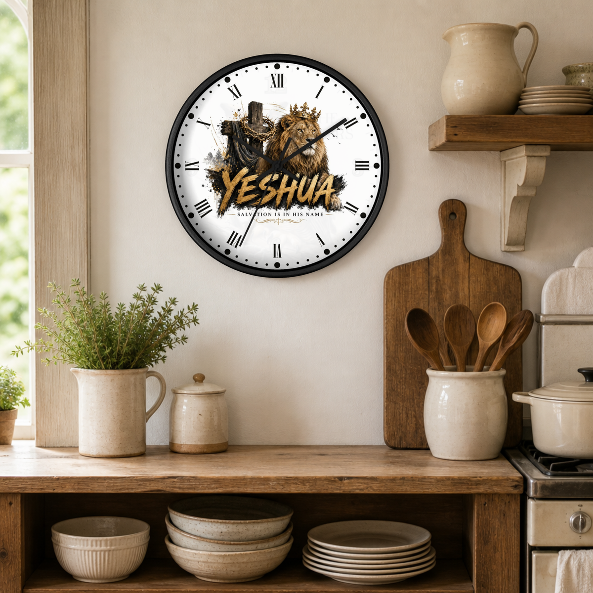 A round wall clock with a black frame hangs on a beige wall in a rustic kitchen setting. The clock face is white with black Roman numerals and features a graphic of a lion wearing a crown and the word 'YESHUA' in large gold letters.